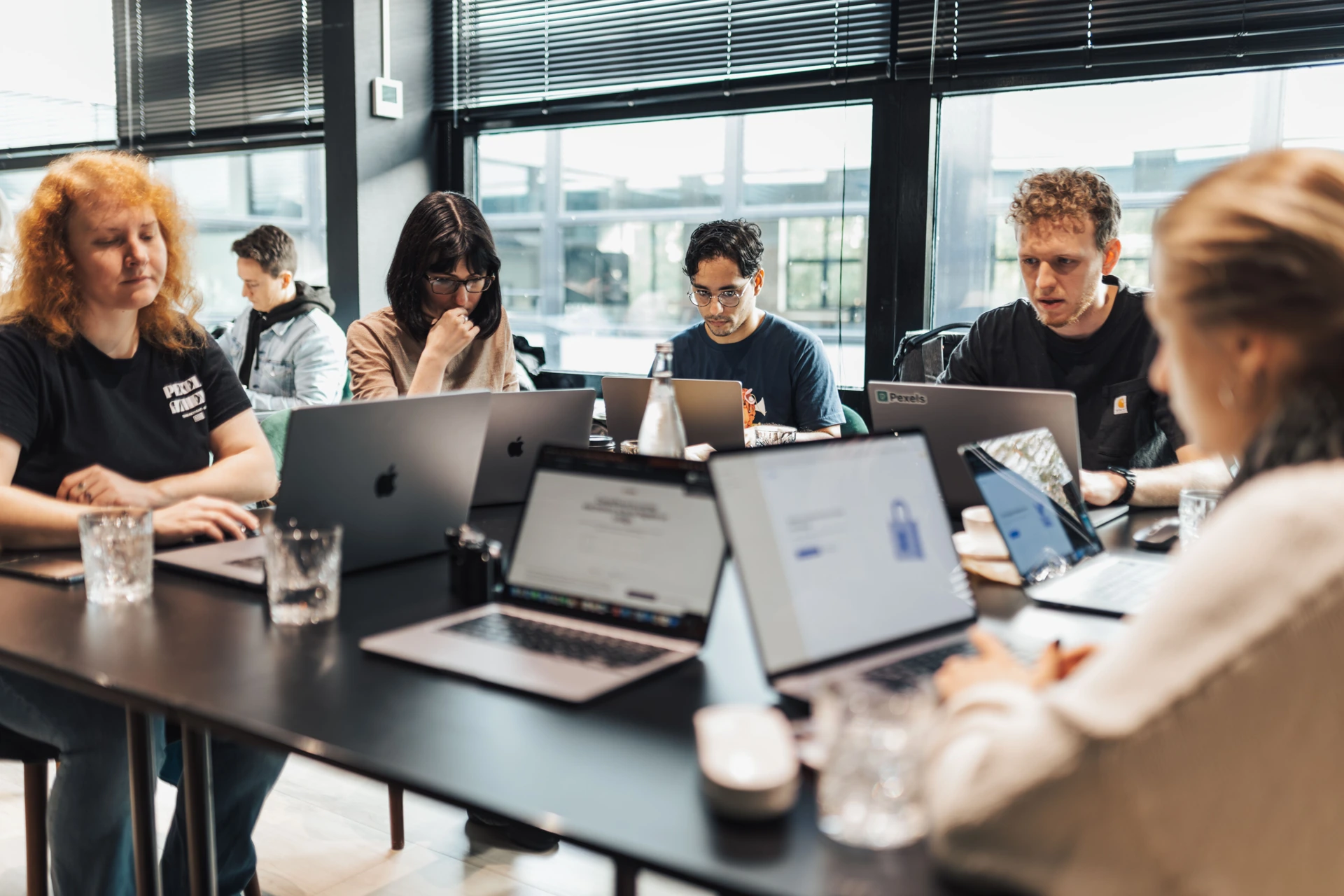 A diverse team practicing digital skills with laptops and shared guidance in a hands-on training workshop